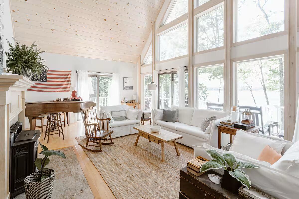 A spacious living room with a large window, a fireplace, and a dining area.