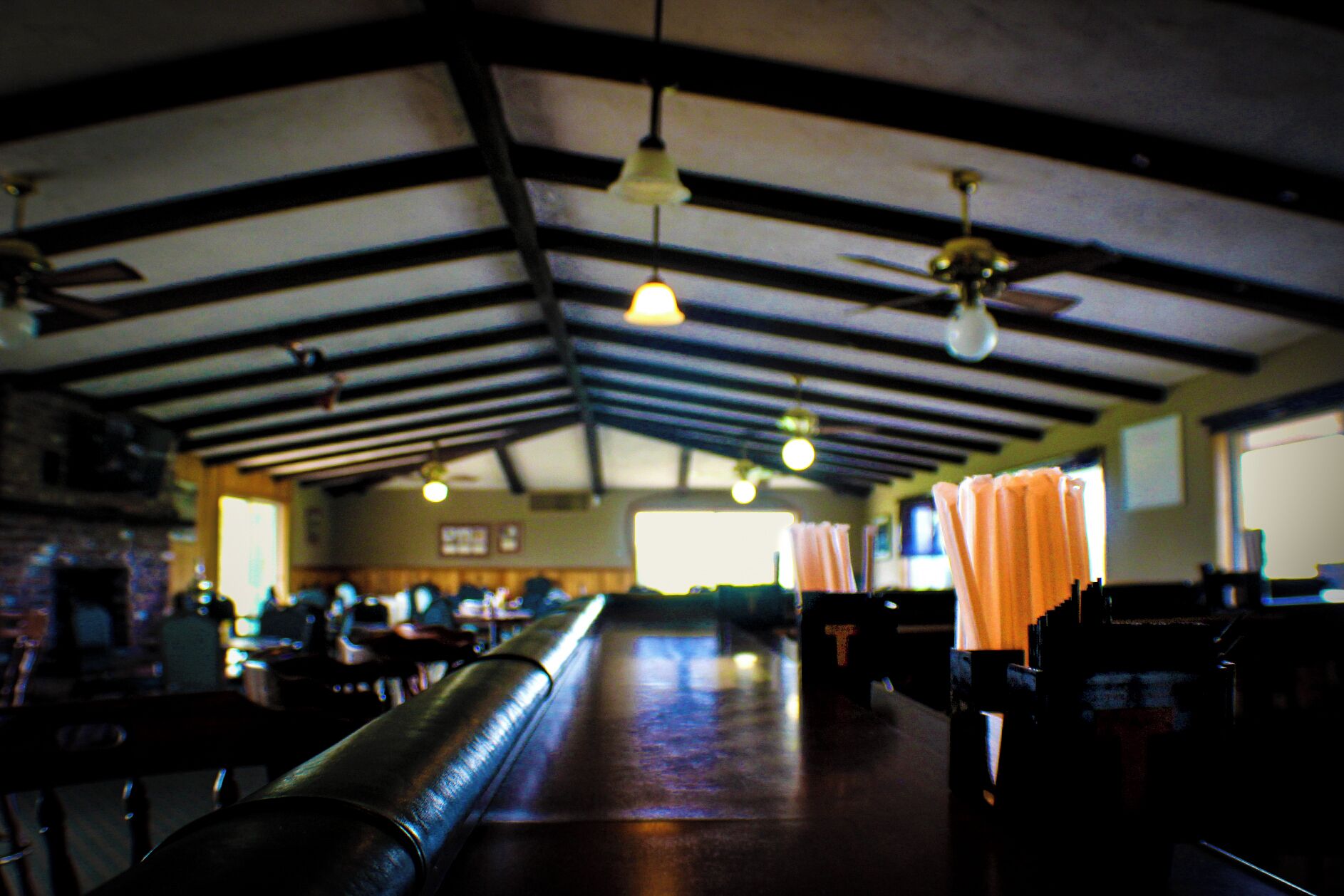 A spacious indoor area with high ceilings, exposed beams, and a long counter.