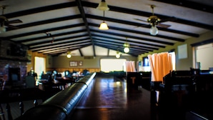 A spacious indoor area with high ceilings, exposed beams, and a long counter. - Thousand Islands Country Club (Wellesley Island)