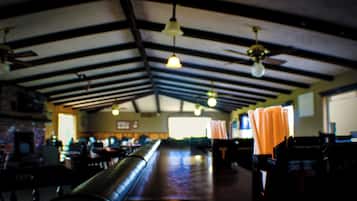 A spacious indoor area with high ceilings, exposed beams, and a long counter.