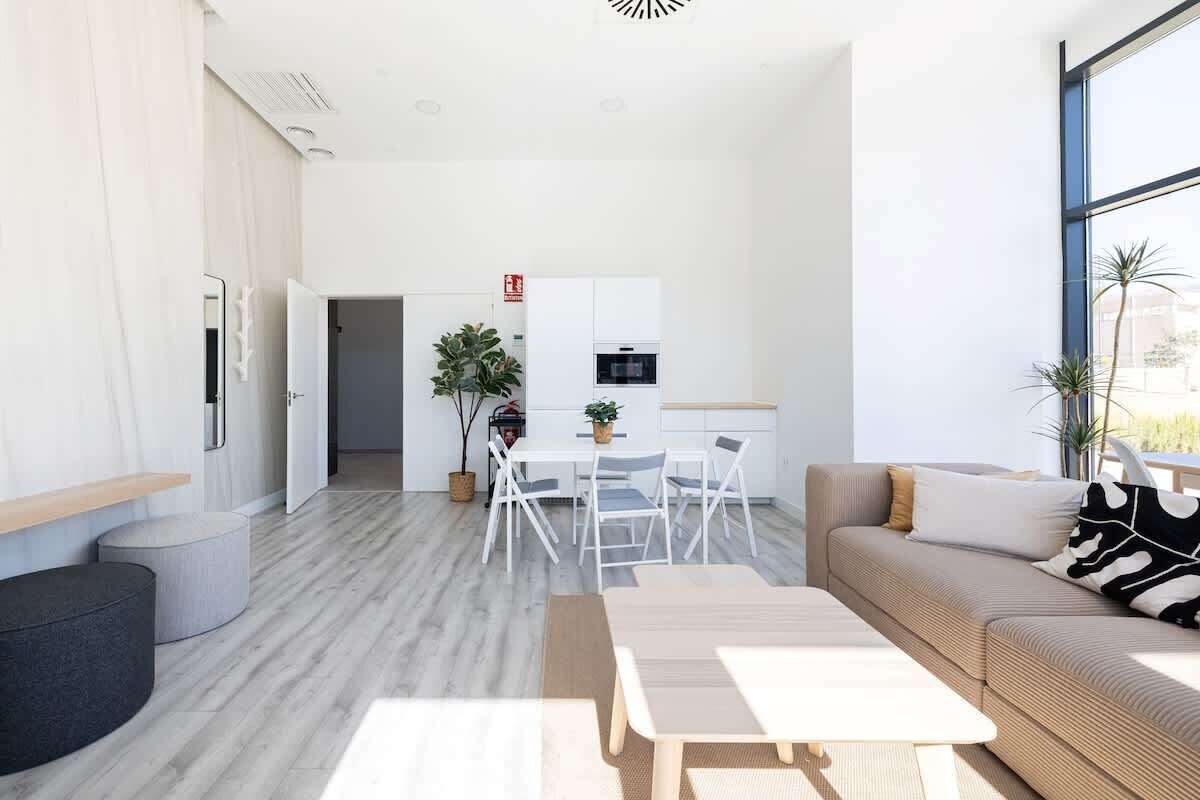 A modern living room with a sofa, coffee table, and dining area.