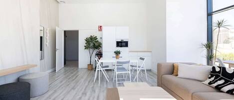 A modern living room with a sofa, coffee table, and dining area.