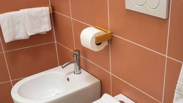 Un baño con bidé, inodoro y lavamanos.