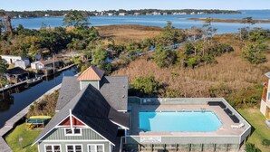 En bostadsfastighet med en swimmingpool, en brygga och utsikt över en sjö och en avlägsen kustlinje.