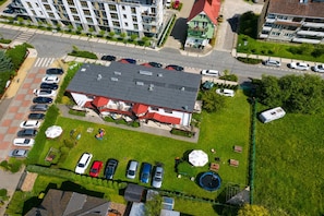 A residential building with a parking lot, a green lawn, and a small garden area.
