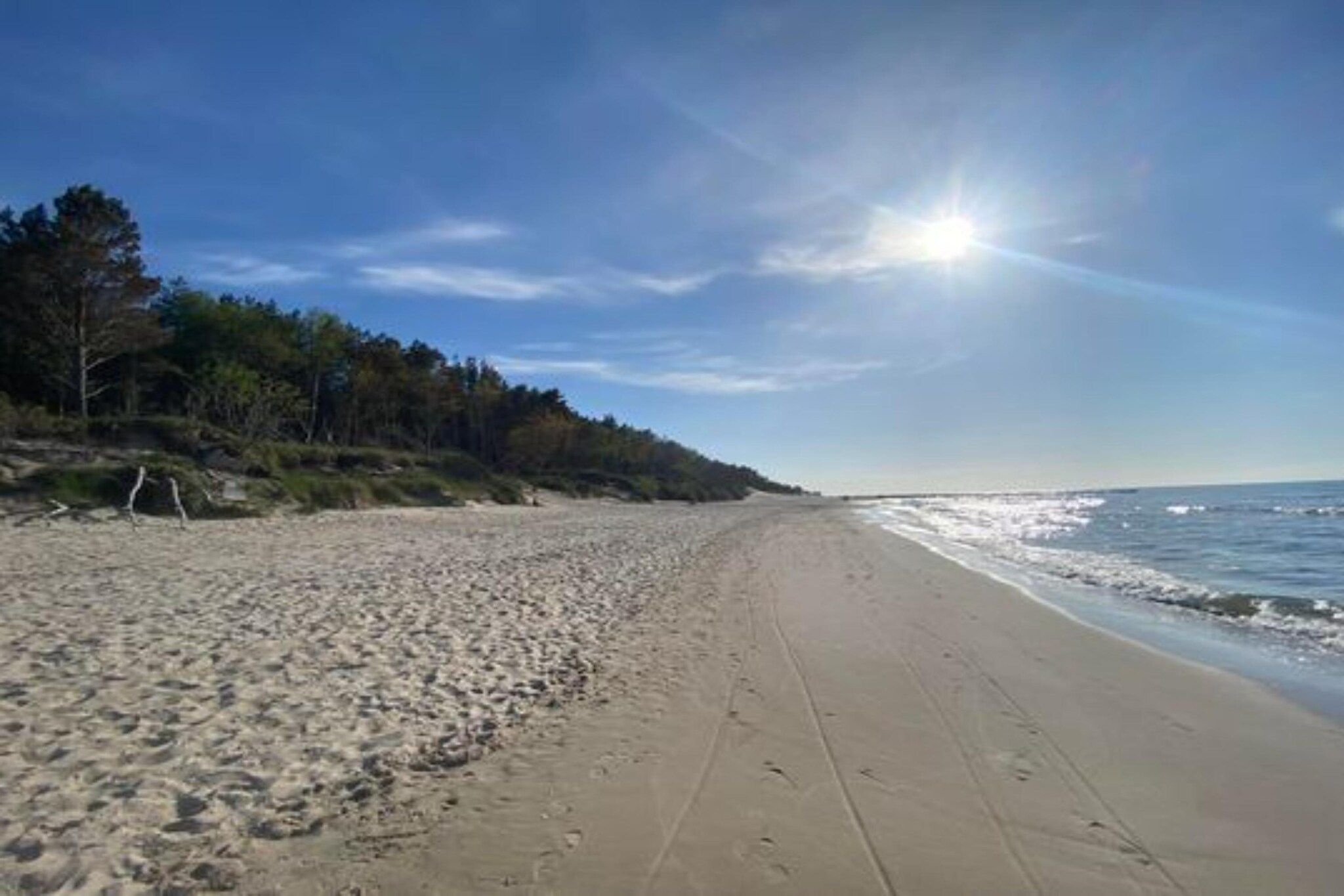 A beach with a clear sky and sunlight.