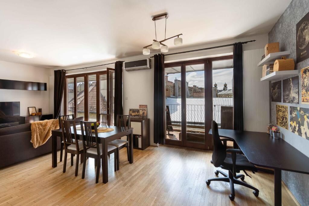 Ein modernes Wohnzimmer mit Essbereich, großen Fenstern und einem Balkon.