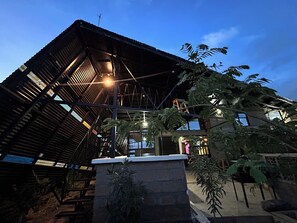 Ein Gebäude mit Metallbedachung, einem Steinunterbau und einer Treppe, die zu einer oberen Ebene führt.