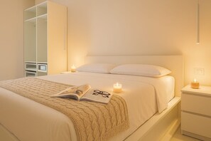Quarto com cama, mesa de cabeceira e guarda-roupa.