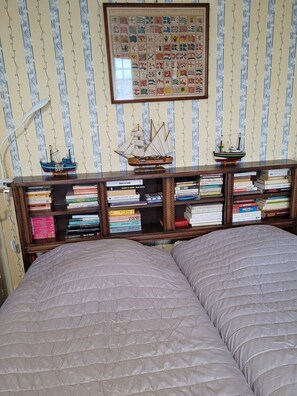A room with a bookshelf, two beds, and a wall with a flag chart. - Apartment 'Saint malo plage 500m (2e étage)' (Saint-Malo)