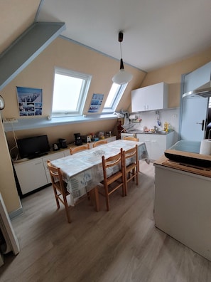 A compact kitchen with a dining area, a built-in oven, and a window with a view. - Apartment 'Saint malo plage 500m (2e étage)' (Saint-Malo)