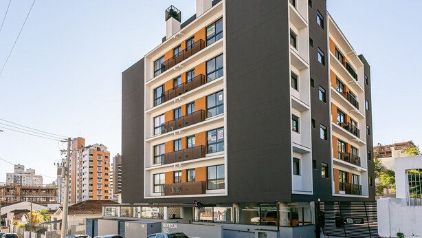 Un immeuble résidentiel à plusieurs étages, doté de balcons, d’une entrée sécurisée et d’une enseigne bien visible indiquant l’adresse.