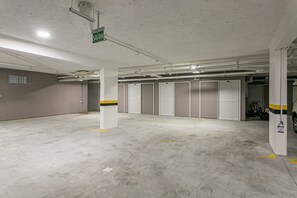Eine Parkgarage mit Betonböden, weißen Wänden und geschlossenen Garagentoren.