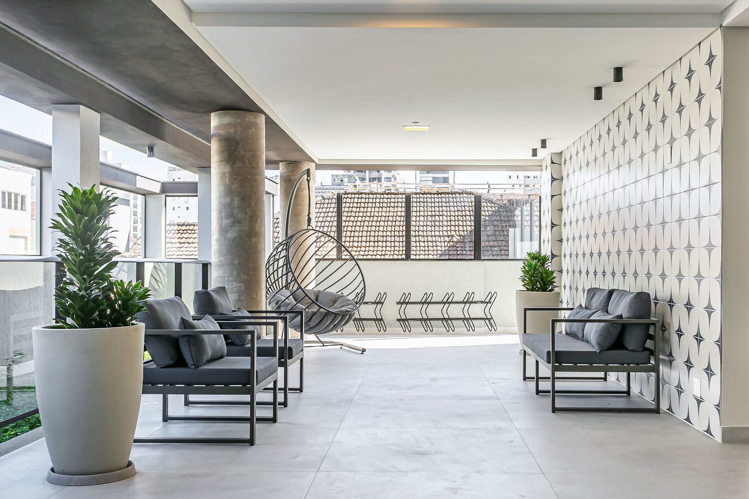 Un espace de détente moderne, doté de sièges, d’un grand bac à plantes et d’un mur orné de motifs.
