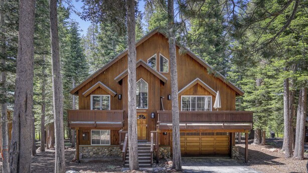 A two-story wooden cabin with a stone foundation, a front entrance, and a garage. - Woodland Truckee Retreat (Truckee)