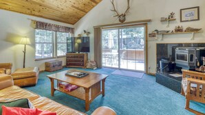 A cozy living room with a fireplace, leather furniture, and a television. - Woodland Truckee Retreat (Truckee)