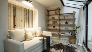 A modern living room with a sofa, a coffee table, a bookshelf, and a large window with a view. - Hestia en Arenales 2900 (Buenos Aires)