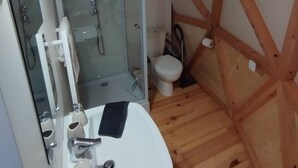 A compact bathroom with a shower, toilet, and sink.