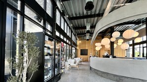 Un interior moderno con ventanas amplias, una mesa de recepción y una zona de estar.