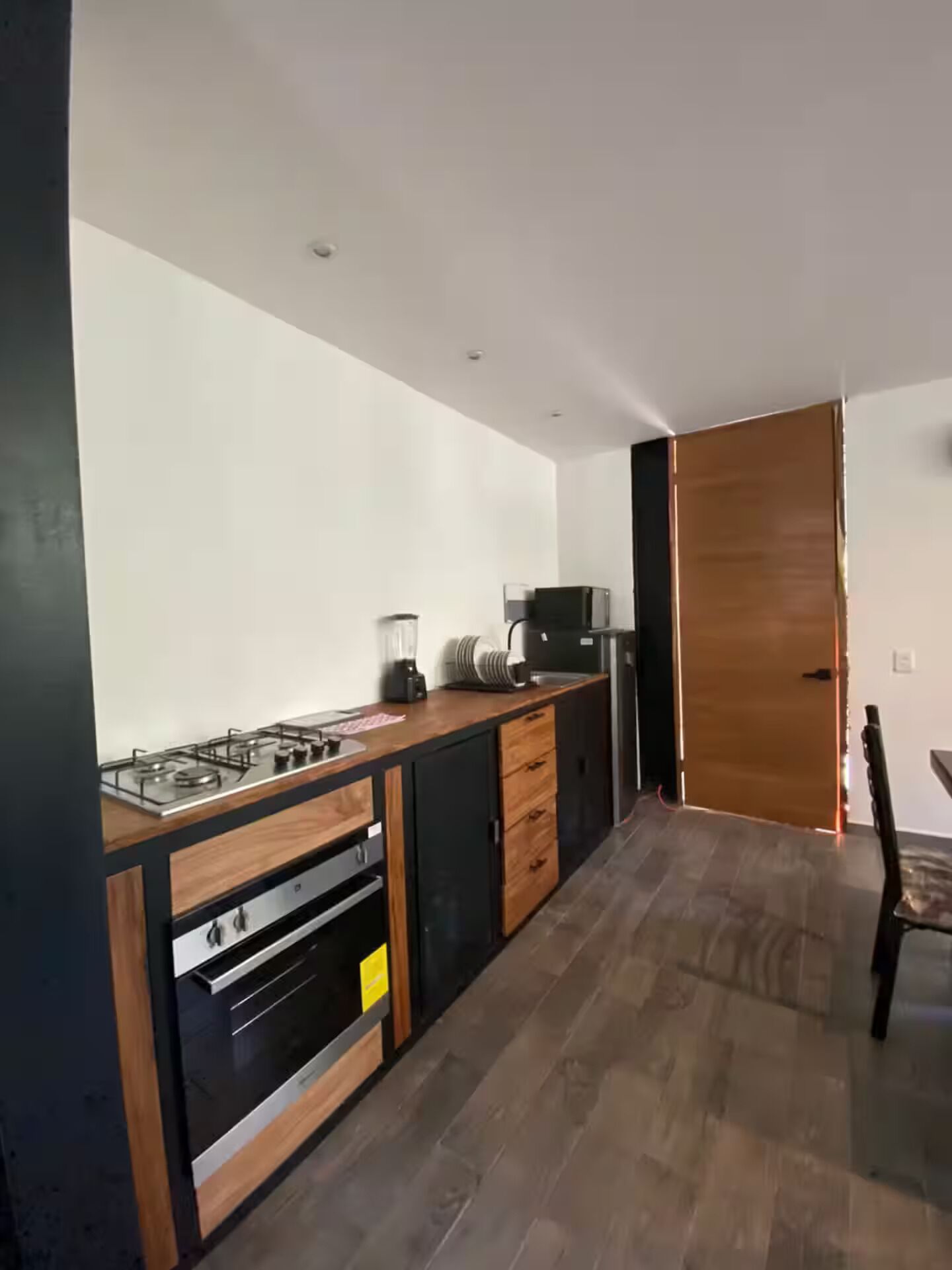 Une cuisine moderne équipée d’une cuisinière à gaz, d’un four à micro-ondes et de meubles de rangement en bois.
