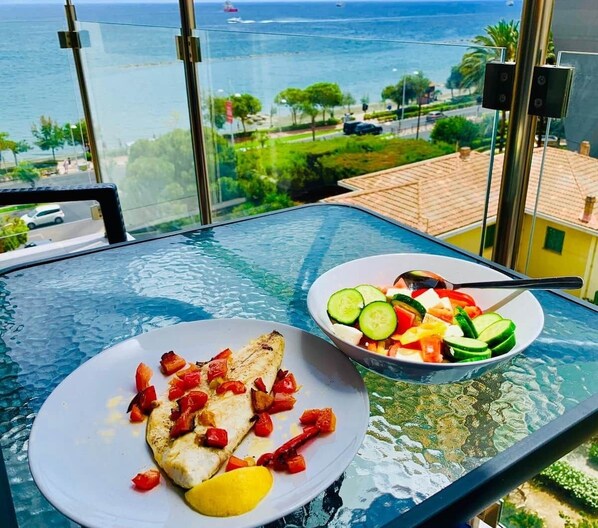 Une table à manger, un repas et une vue sur la mer.