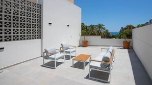 A rooftop terrace with outdoor seating, a view of the sea, and potted plants. - Bridge House 202-2BR Modern Apt. (Limassol)