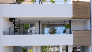 A multi-story building with balconies, large windows, and potted plants. - Bridge House 202-2BR Modern Apt. (Limassol)