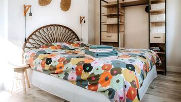Een slaapkamer met een bed, een houten hoofdbord, een wandplank en een inbouwkast.