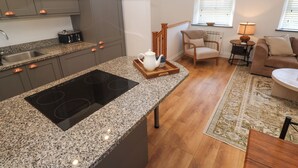 Una cocina moderna con encimeras de granito, estufa integrada y pileta de acero inoxidable.