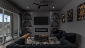Een moderne woonkamer met een flatscreen televisie, comfortabele zitplaatsen en een hond.