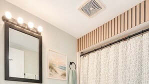 Ein Badezimmer mit Waschtisch, Spiegel und Toilette.