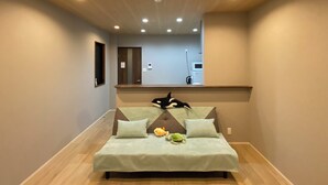 Une chambre à coucher comprenant un lit, des oreillers, une table de chevet, un miroir, une porte et un plafond doté d’un éclairage encastré.