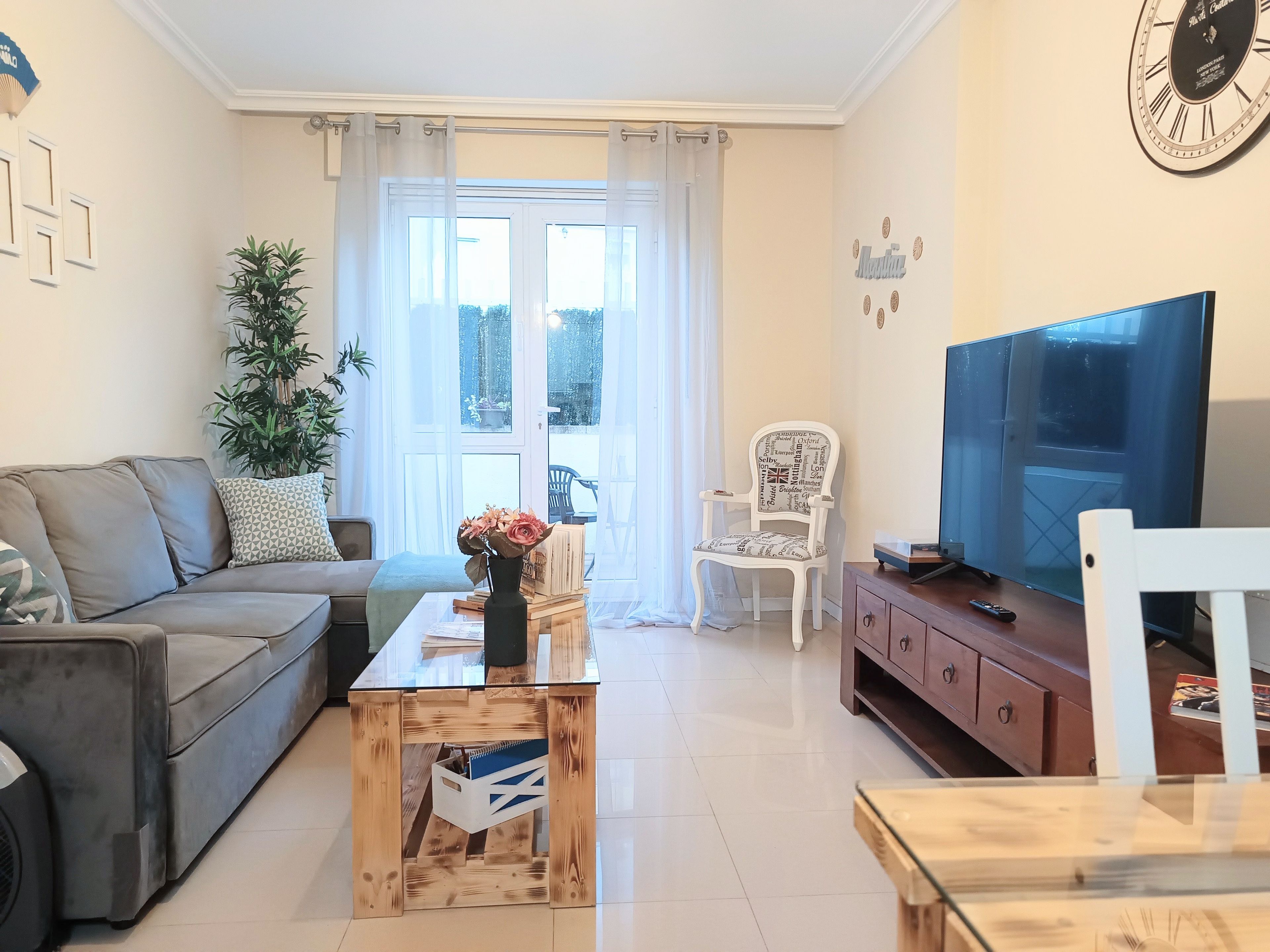 A living room with a sofa, a coffee table, a TV, and a chair.
