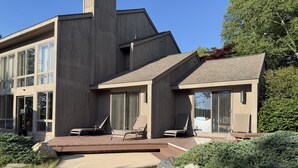 Una casa moderna con una amplia terraza, varios ventanales y una zona de estar al aire libre cubierta.