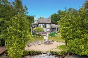 Une maison moderne dotée d’un patio, d’un espace salon extérieur et d’un aménagement paysager naturel.