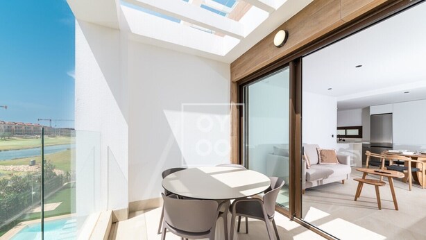 A modern apartment with a glass balcony, a dining area, a living room, and a kitchen. - Velapi Golf Resort Oasis, Luxury apartment with golf views, pool and gym by OYOOSTAYS (Los Alcázares)