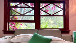 A bed with pillows and a view of pink flowers through a window. - Hollywood Hills Home with Casita: Perfect Multi-Generational Family Compound (Los Angeles)