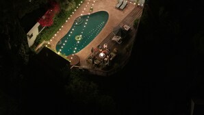 An aerial view of a swimming pool with surrounding deck seating and a fire pit area. - Hollywood Hills Home with Casita: Perfect Multi-Generational Family Compound (Los Angeles)
