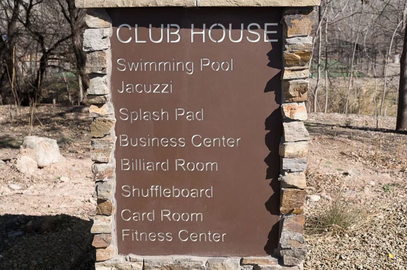 Une affiche indiquant les équipements disponibles, notamment une piscine, un jacuzzi, un espace de jeux d’eau, un centre d’affaires, une salle de billard, une table de jeu de palets, une salle de jeux de cartes et un centre de remise en forme.