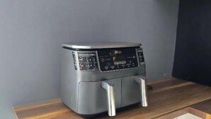 A compact kitchen with a built-in microwave, a small air fryer, and a wooden countertop. - Pavillon Beauséjour (Amqui)