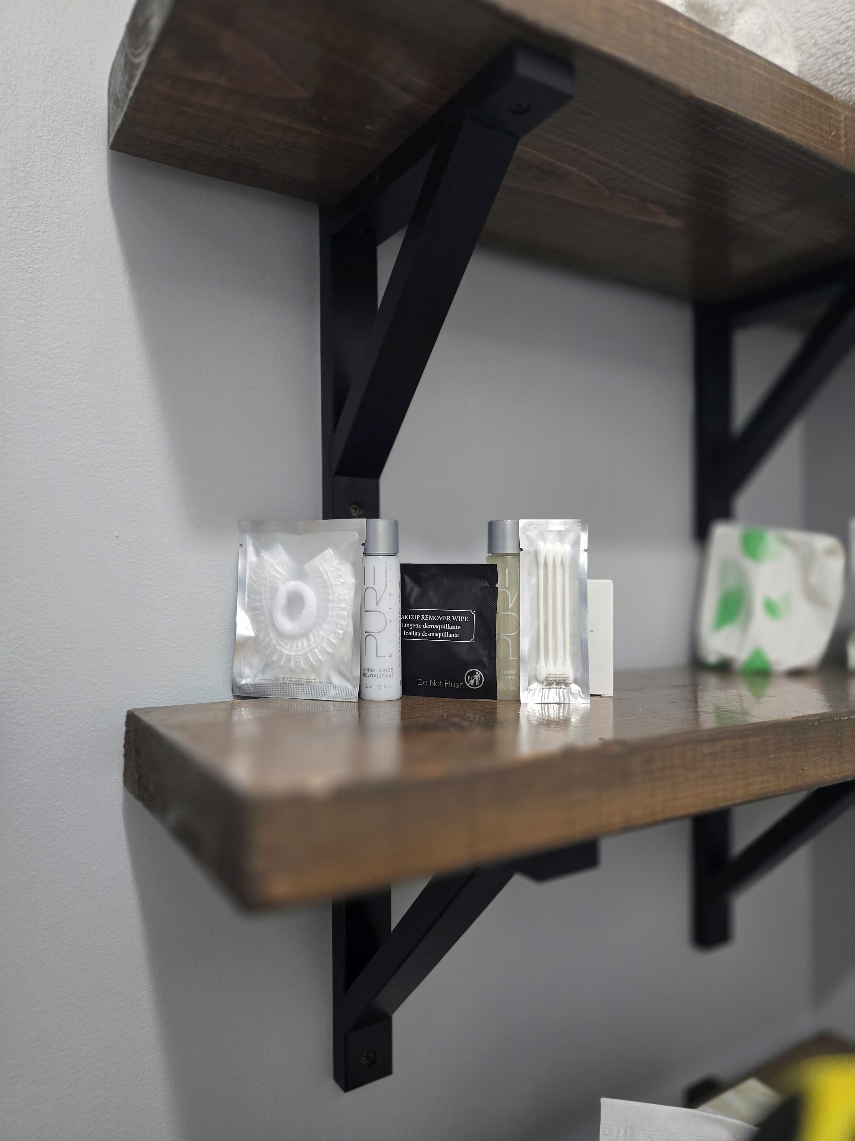 A shelf with makeup remover wipes, a bottle of lotion, and a small container.