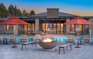 A poolside area with a fire pit, lounge chairs, and umbrellas. - Safari Luxury Tent - Couples Getaway,30 Min. to Sedona (Camp Verde)