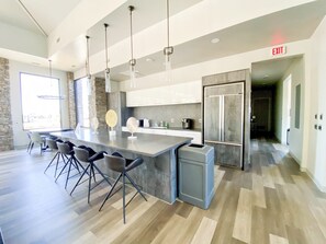A modern kitchen with a central island, bar stools, stainless steel appliances, and an exit sign. - Safari Luxury Tent - Couples Getaway,30 Min. to Sedona (Camp Verde)