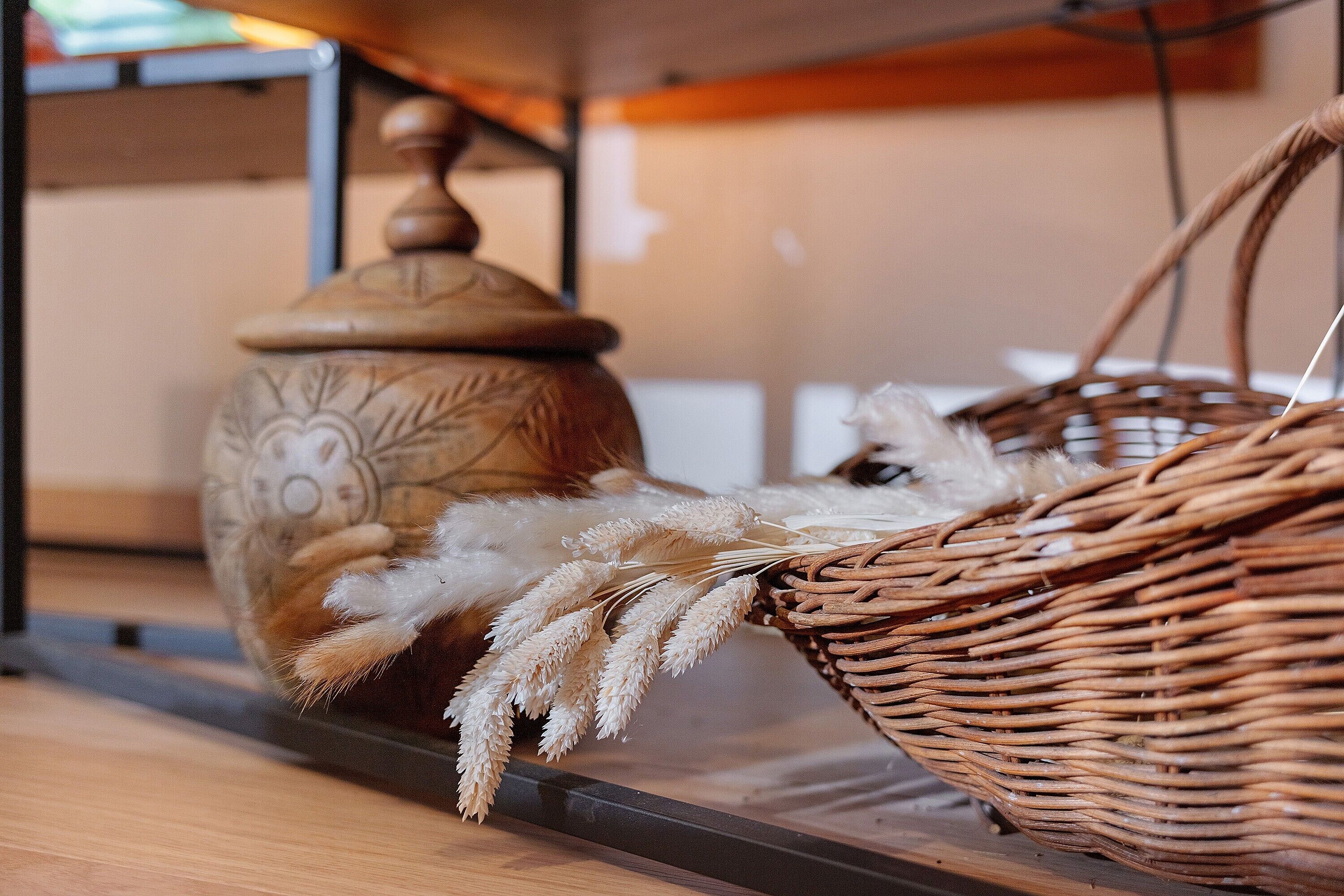 Un panier en osier contenant un objet blanc et duveteux, posé sur une étagère.
