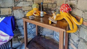 A wooden table with a bottle of wine, two plush toys, and a blue cloth.