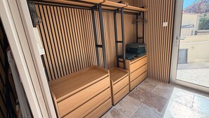 A room with a sliding door, a wooden bench, a small table, and a hanging rack.