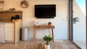 A modern kitchen with a built-in oven, a coffee machine, and a small dining area with a table and chairs.