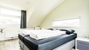 A modern bedroom with a loft bed, a bedside table, a lamp, and a window with curtains. - Gem With Dune Views for 4 (Vlissingen)