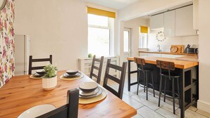Un coin repas avec une table en bois, des chaises et une petite plante en pot.