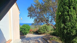 A stone pathway leading to a building with a view of the sea. - Air-Conditioned Mas Juan Villa with Pool and Large Garden in a Quiet Setting, Panoramic Ocean View (Bormes-les-Mimosas)